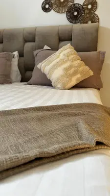 a bed with a brown blanket and pillows on it at VILLA Zamzam in Marrakech