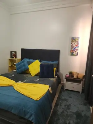 a bedroom with a bed with blue and yellow pillows at Chez zhirou in Marrakech