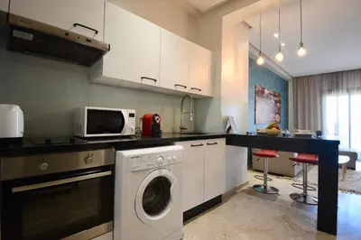 a kitchen with a washing machine and a microwave at Central location-Queensize bed- Parking, AC & Iptv in Marrakech