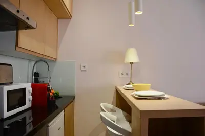 a small kitchen with a table and a microwave at 1BR Studio-AC & IpTV-Downtown Gueliz-perfect for 2 in Marrakech