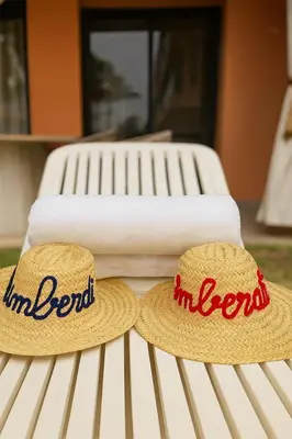 two towels and two hats sitting on a bench at Amberdi Noria Apartment Marrakech in Marrakech