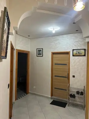 a hallway with a wooden door in a room at Apartment near the airport in Marrakech