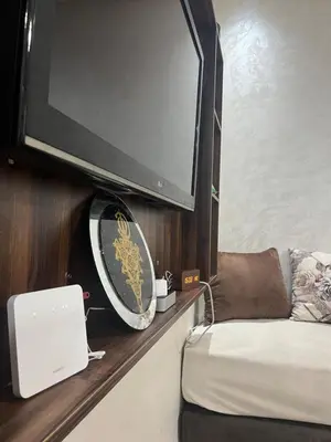 a flat screen tv on a wall with a couch at Apartment near the airport in Marrakech