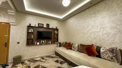 a living room with a couch and a tv at Apartment near the airport in Marrakech