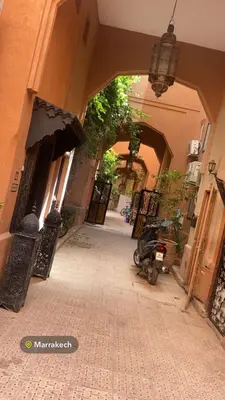 an alley way with an archway in a building with a scooter at Riyad jennah in Marrakech