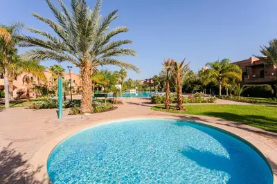 a swimming pool in a resort with palm trees at Atlas Golf Resort - piscine - rooftop in Marrakech