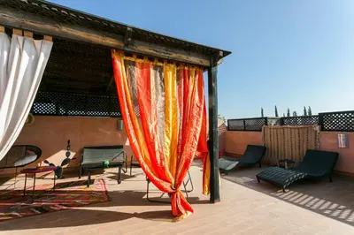 a patio with a curtain and chairs on a roof at Atlas Golf Resort - piscine - rooftop in Marrakech