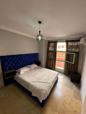 a bedroom with a bed with a blue headboard and a window at Duplexe Mirador Majorelle in Marrakech