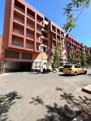 a parking lot in front of a pink building at Duplexe Mirador Majorelle in Marrakech