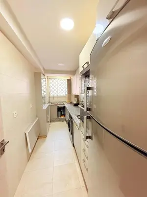 a kitchen with white appliances and a long hallway at Luxueux Aprt A Gat Moderne Centre-ville in Marrakech