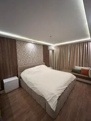 a bedroom with a large white bed and a couch at Appartement avec piscine Marrakech in Marrakech