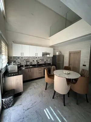 a large kitchen with a table and some chairs at Appartement avec piscine Marrakech in Marrakech