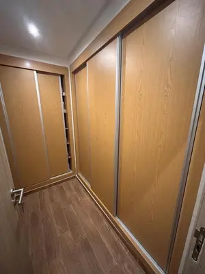 a closet with wooden doors and a wooden floor at Appartement avec piscine Marrakech in Marrakech