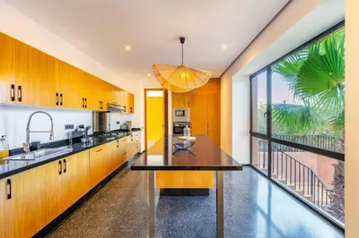 a kitchen with wooden cabinets and a large window at La Villa Karl in Marrakech