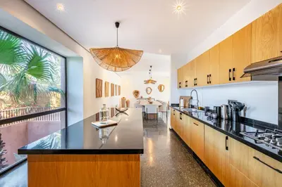 an open kitchen with wooden cabinets and a large window at La Villa Karl in Marrakech