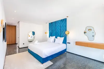 a bedroom with a bed with a blue headboard at La Villa Karl in Marrakech