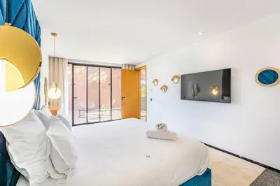 a bedroom with a large bed with a tv on the wall at La Villa Karl in Marrakech