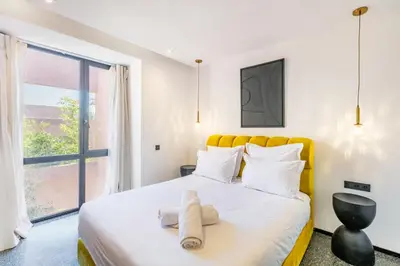 a bedroom with a bed with a yellow headboard and a window at La Villa Karl in Marrakech