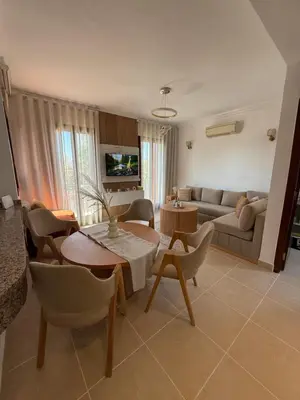 a living room with a table and a couch at Appartement La Palmeraie Marrakech in Marrakech
