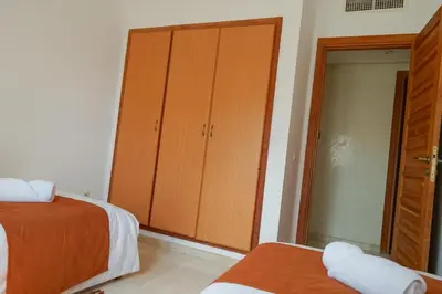 a bedroom with two beds and a large closet at Peaceful 2BR Oasis with Pool Tennis AC - Palmeraie in Marrakech