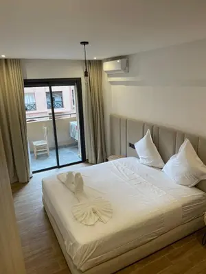 a bedroom with a bed with white sheets and a window at Palmeraie Gates in Marrakech