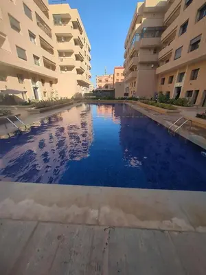 a swimming pool in front of some apartment buildings at Palmeraie Gates in Marrakech