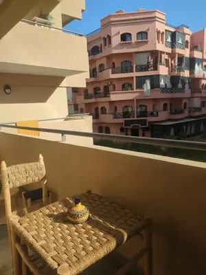 a table and chair on a balcony with a building at Palmeraie Gates in Marrakech