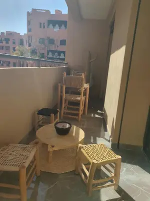 a room with a table and chairs on a balcony at Palmeraie Gates in Marrakech