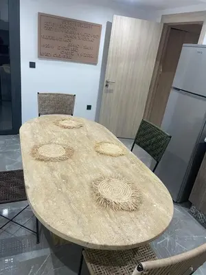 a table in a room with chairs and a refrigerator at Palmeraie Gates in Marrakech