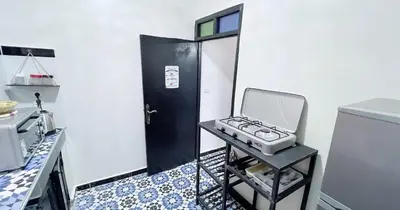 a kitchen with a machine on a stool in front of a door at Dar ESSEKIA in Marrakech