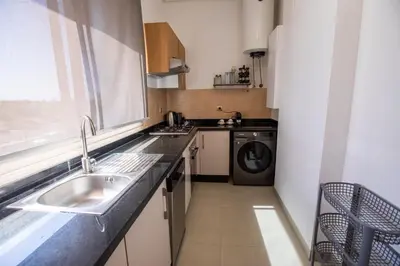 a small kitchen with a sink and a washing machine at Marrakech confort et détente à Argan Golf prestigia in Marrakech