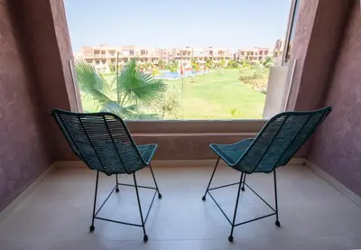 two chairs sitting in front of a window at Marrakech confort et détente à Argan Golf prestigia in Marrakech