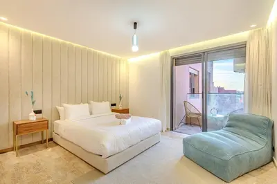 a bedroom with a bed and a blue chair at 1BR appt in the centre gueliz in Marrakech