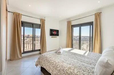 a bedroom with a bed and large windows at Super apartment in marrrakech in Marrakech