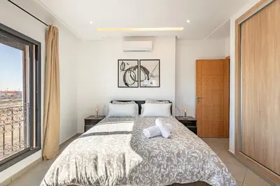 a bedroom with a large bed and a large window at Super apartment in marrrakech in Marrakech