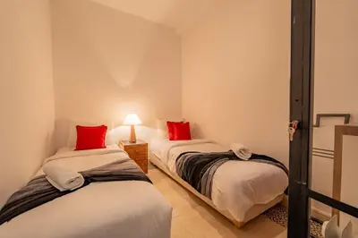 two beds in a room with red pillows at Dar KADO, Charming Hideaway in the Heart of Marrakech Medina in Marrakech