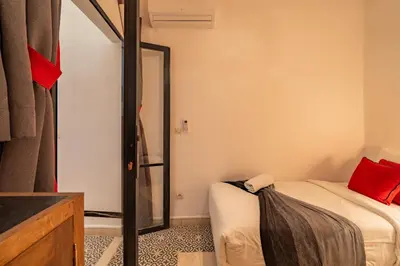a small room with a bed and a mirror at Dar KADO, Charming Hideaway in the Heart of Marrakech Medina in Marrakech