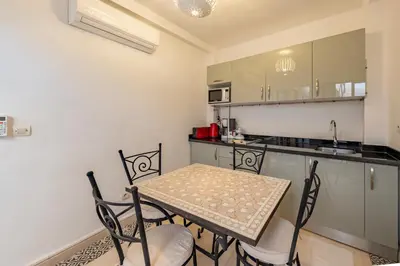 a small kitchen with a table and chairs at Dar KADO, Charming Hideaway in the Heart of Marrakech Medina in Marrakech