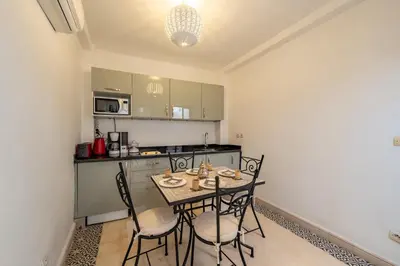 a kitchen with a table and chairs in a room at Dar KADO, Charming Hideaway in the Heart of Marrakech Medina in Marrakech
