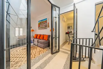 a living room with a couch and glass doors at Dar KADO, Charming Hideaway in the Heart of Marrakech Medina in Marrakech