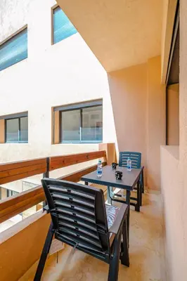 a balcony with two chairs and a table at 3 min de Guéliz - Appart avec balcon , vue piscine in Marrakech