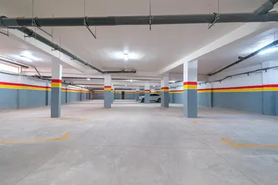 an empty parking garage with red yellow and white columns at 3 min de Guéliz - Appart avec balcon , vue piscine in Marrakech