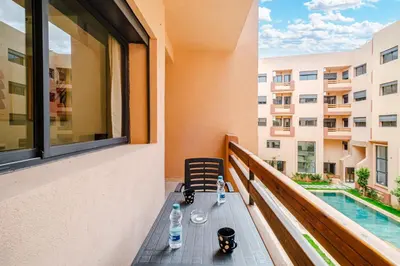 a table on a balcony with a view of a building at 3 min de Guéliz - Appart avec balcon , vue piscine in Marrakech