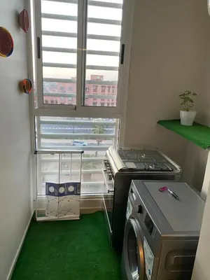 a small kitchen with a stove and a green floor at Luxury Apartment Near Airport & Medina in Marrakech