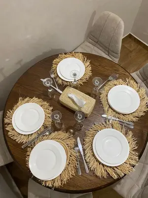 a wooden table with white plates and utensils on it at Luxury Apartment Near Airport & Medina in Marrakech