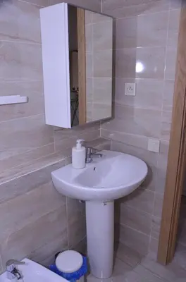 a bathroom with a sink and a mirror and a toilet at Appartement moderne in Marrakech