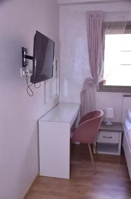 a room with a desk and a tv on a wall at Appartement moderne in Marrakech