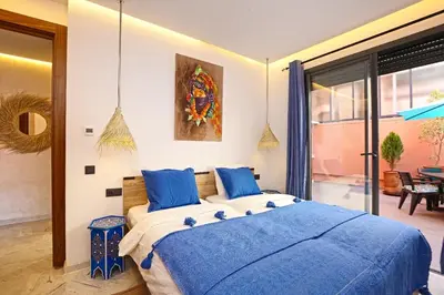 a bedroom with a large bed with blue pillows at Heart of City 2BR 2Patios Fiber AC Modern New Calm in Marrakech