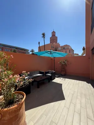 a patio with a table and an umbrella on a building at Heart of City 2BR 2Patios Fiber AC Modern New Calm in Marrakech
