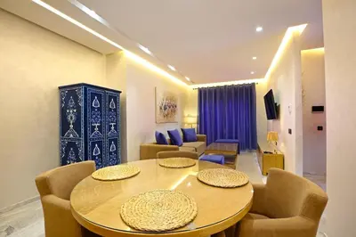 a living room with a table and chairs at Heart of City 2BR 2Patios Fiber AC Modern New Calm in Marrakech